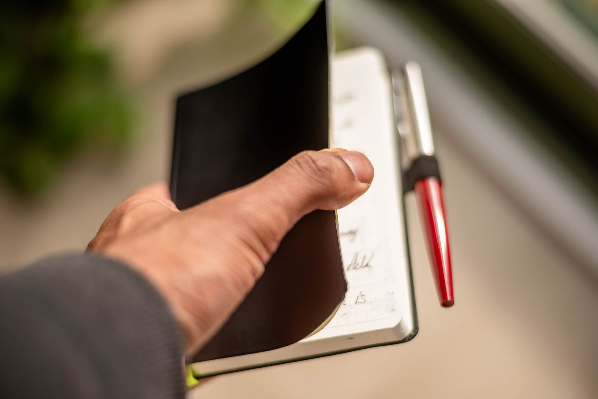 Holding a small journal with a fountain tip pen