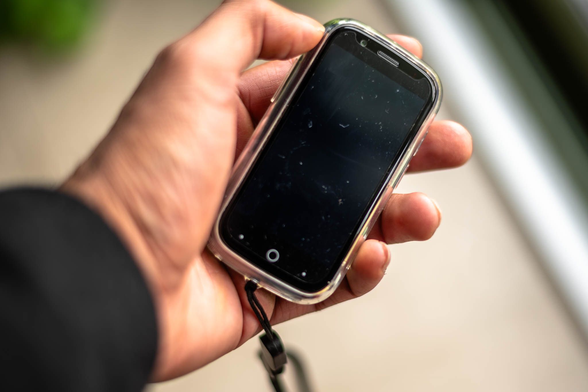 Holding a small smartphone showing the front