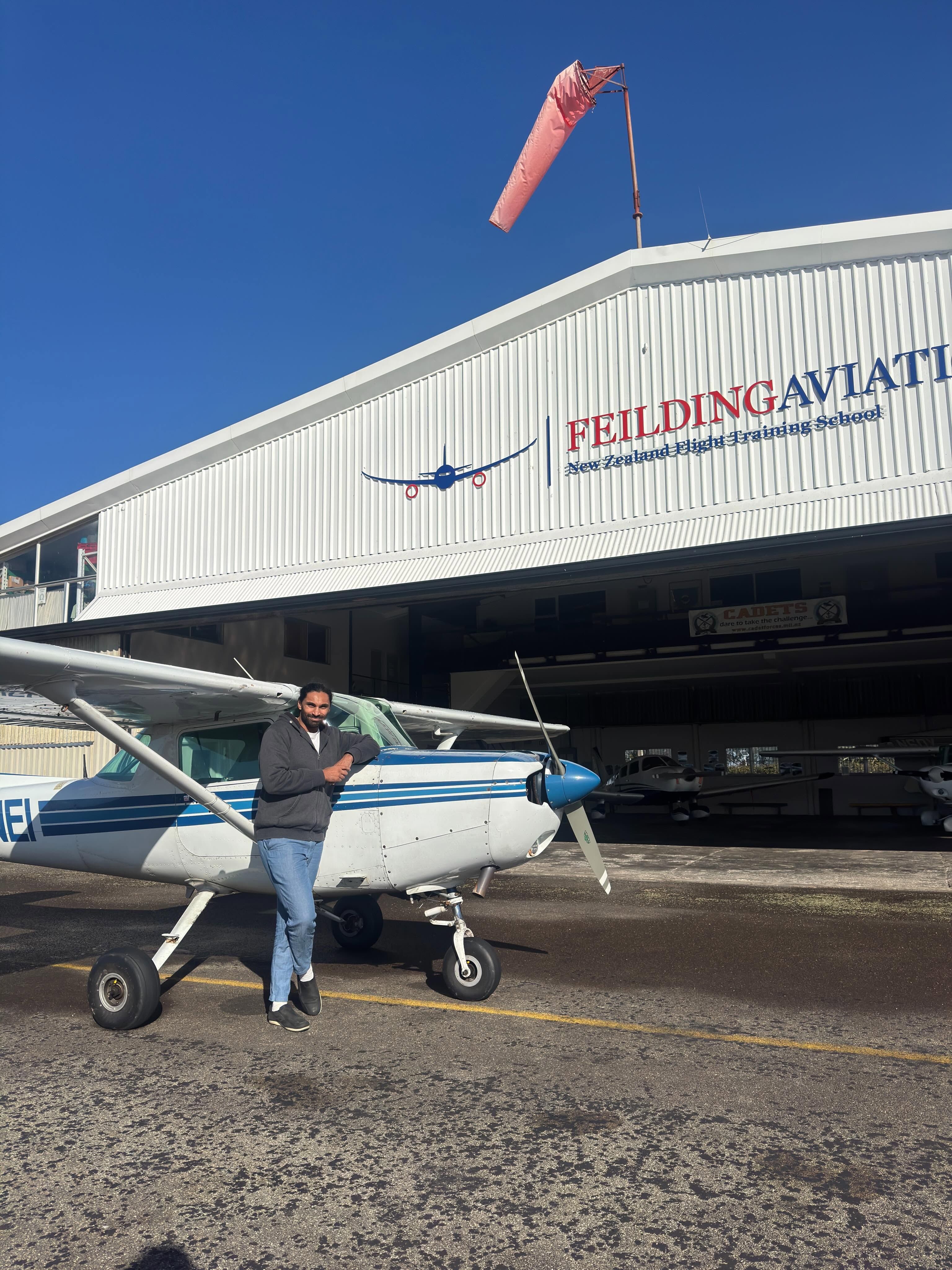 A man standing in front of a single engine plane