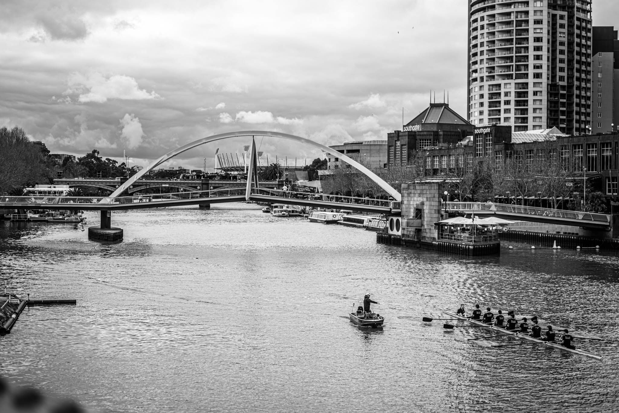 River with a bridge with an arch, a row boat is present in the river