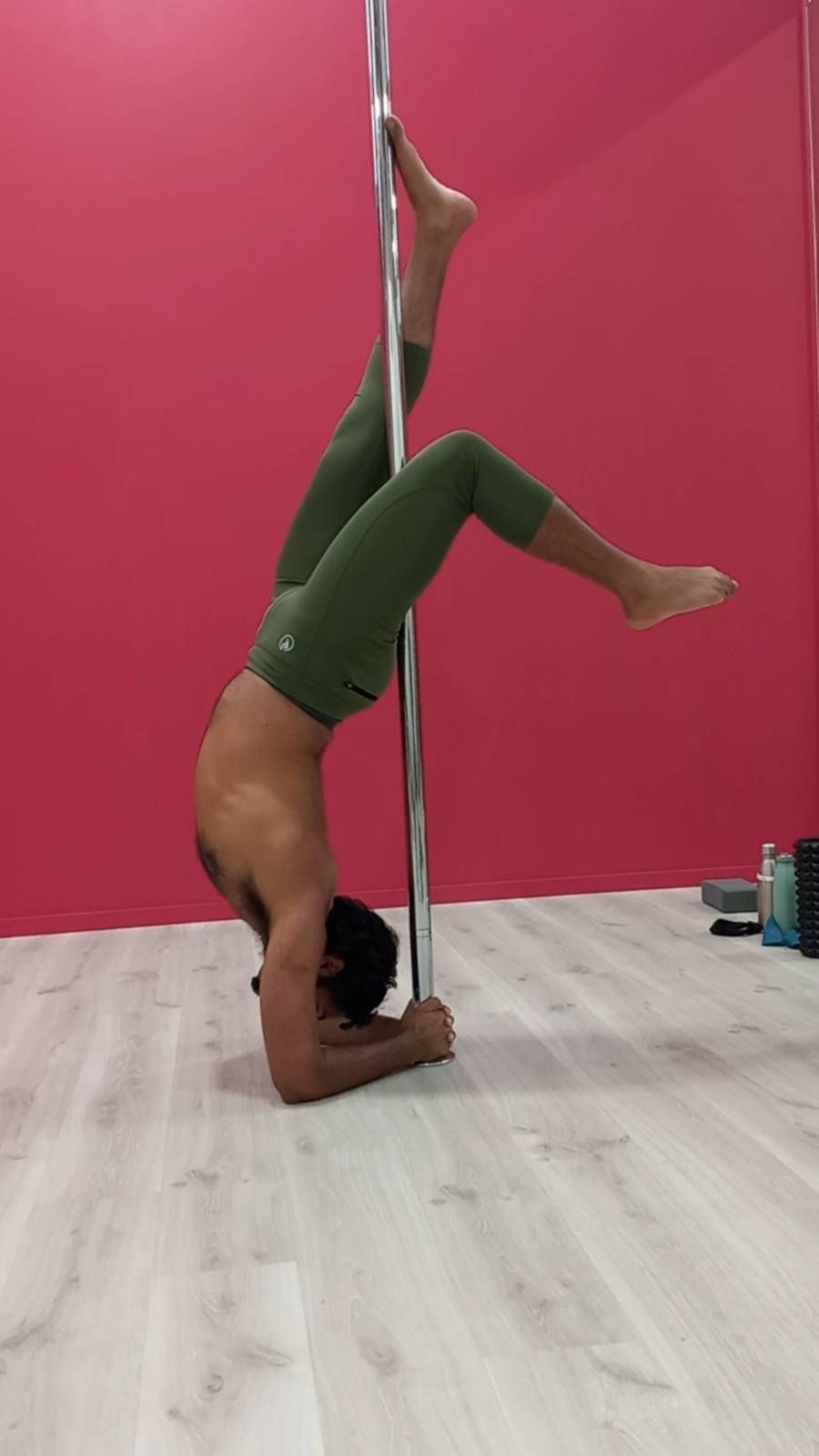 A man upside down agaisnt a pole