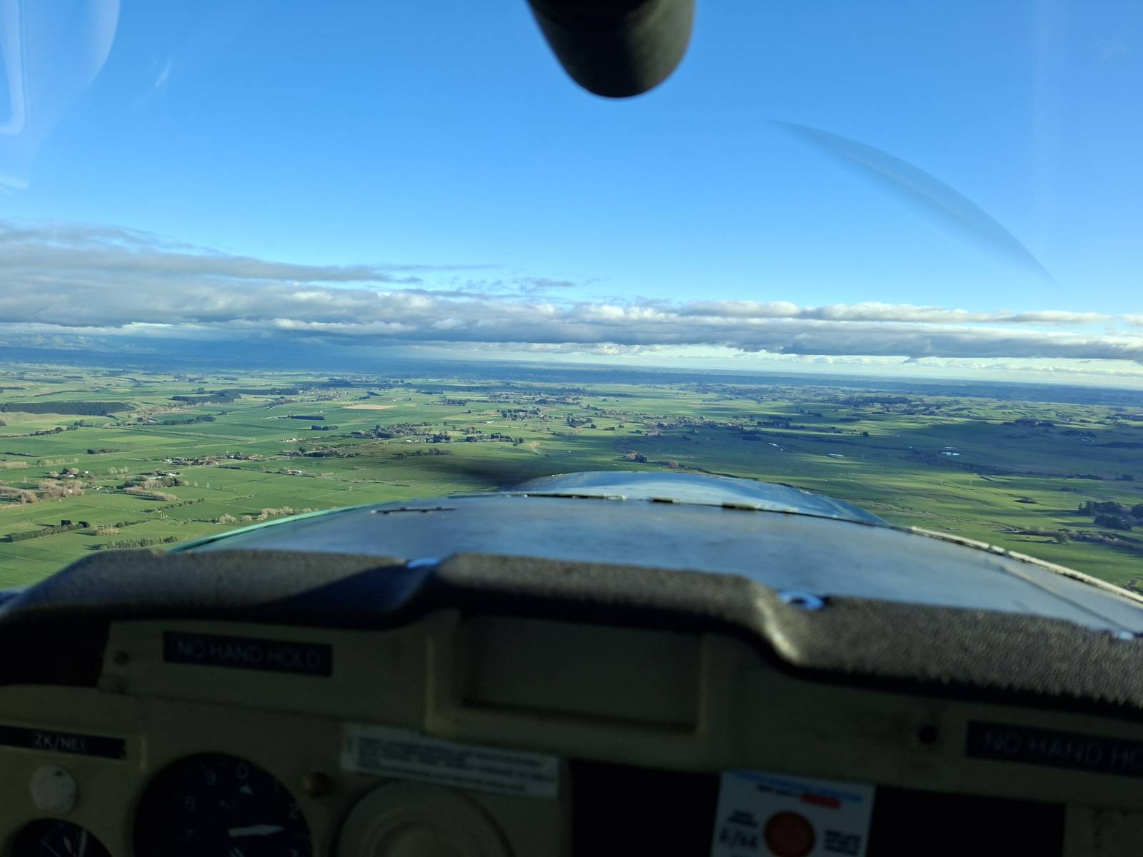 View of land and sky from a cockpit of a small plane
