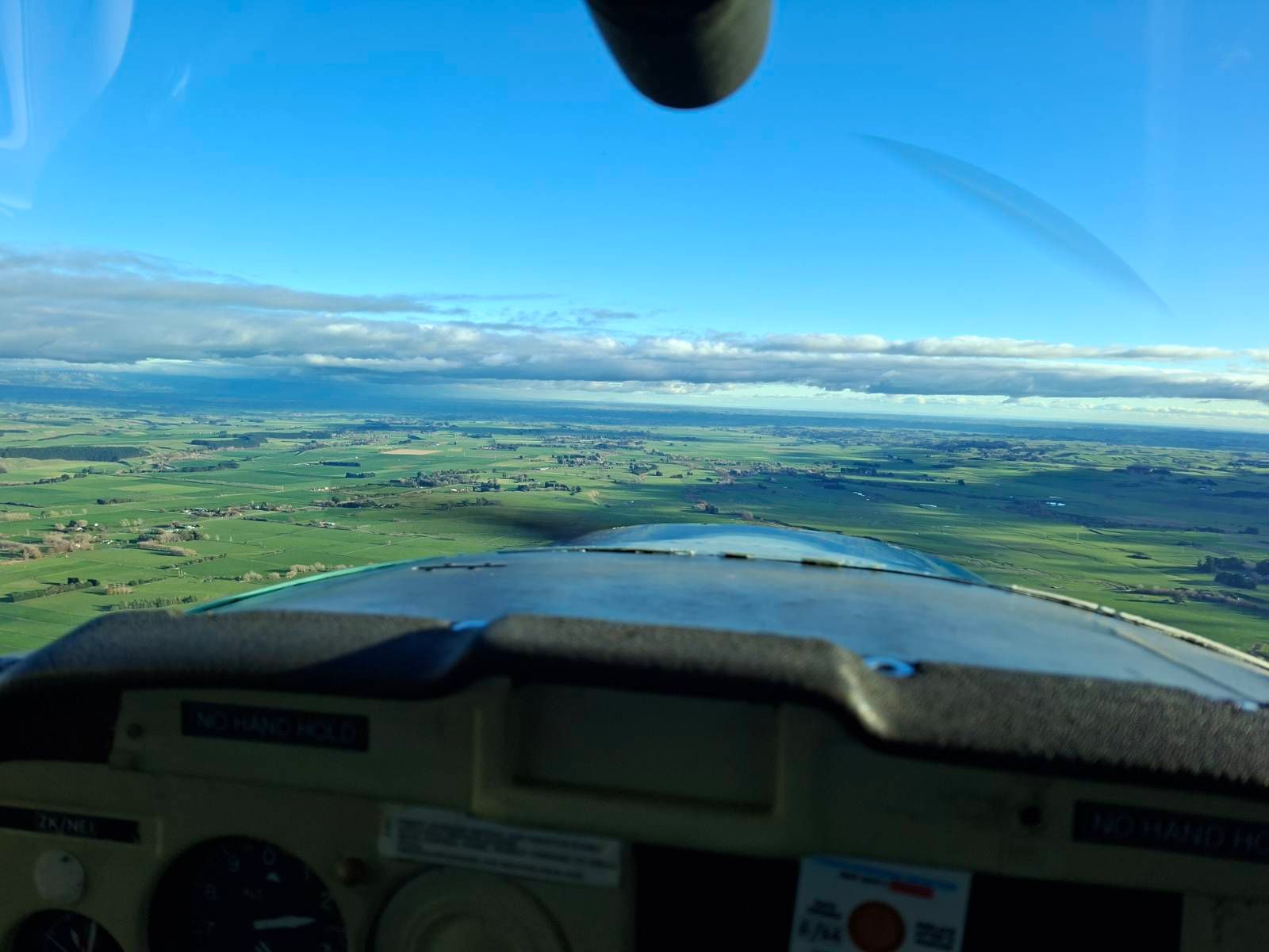 View of land and sky from a cockpit of a small plane